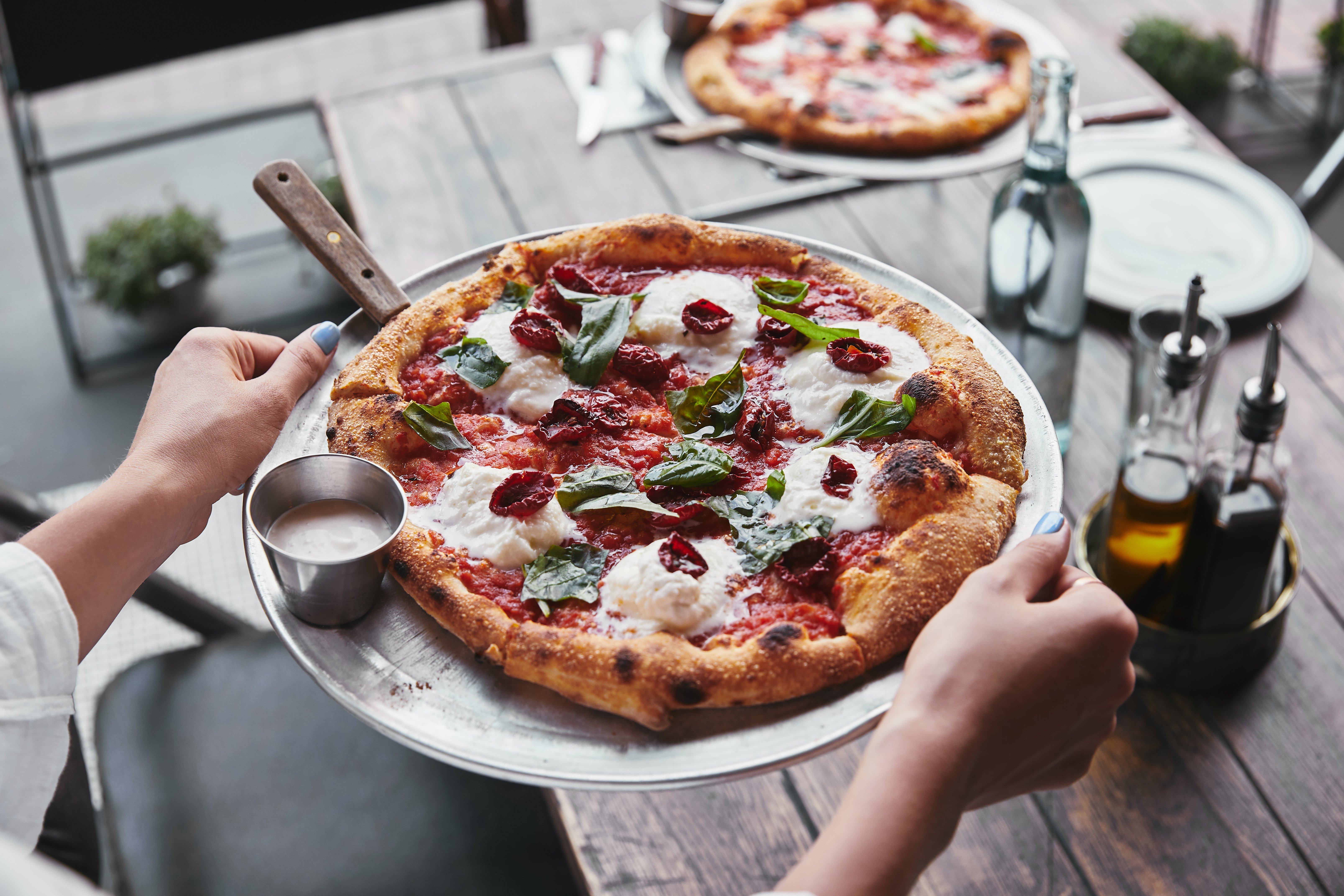 cropped-shot-of-woman-carrying-plate-with-tasty-pi-2022-02-01-22-38-15-utc